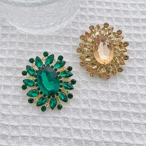 Luxurious vintage flower brooch with emerald green and champagne crystals in gold setting