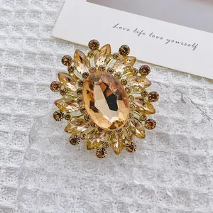 Elegant flower brooch with green crystals and amber stone on a vintage gold base