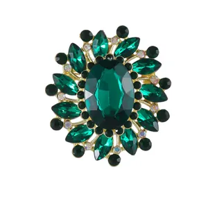 Vintage gold flower brooch with emerald green gemstone and radiant crystal petals