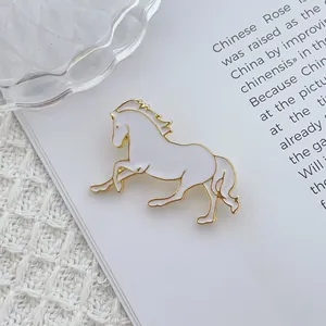 Creative white and gold horse brooch with enamel detailing in an elegant running pose