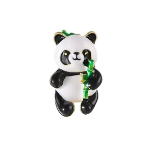 Cute panda holding bamboo enamel brooch with golden metal edges on a white background