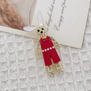 Detalle de un broche de conejo con diamantes de imitación brillantes y esmalte rojo