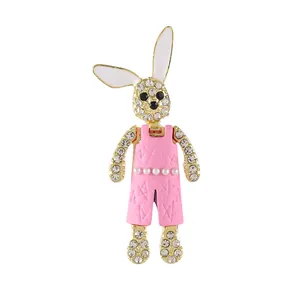 Broche de conejo brillante con peto rosa y diamantes de imitación en fondo blanco