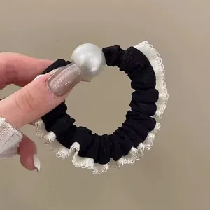 Coletero negro elegante con bordes de encaje blanco y una perla grande decorativa