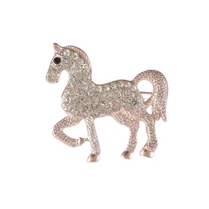 Exquisite rose gold horse brooch with sparkling white rhinestones on white background