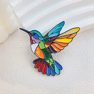 Bunte Kolibri-Brosche mit Emaille-Effekt im Buntglas-Stil auf weißem strukturiertem Grund