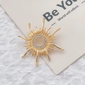 Eleganter goldener Sonnen-Brosche mit funkelnden Strasssteinen auf minimalistischer Karte