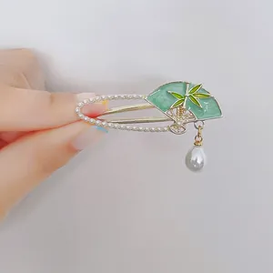 Elegant gold fan-shaped hair clip with bamboo leaf motif and pearl pendant detail