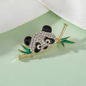Detail of panda brooch with sparkling rhinestones and green bamboo in gold plating