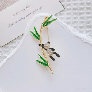 Close-up of cute panda and bamboo brooch with sparkling rhinestones and green enamel details
