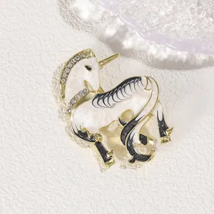 Macro detail of unicorn brooch with white enamel and sparkling inlaid crystals
