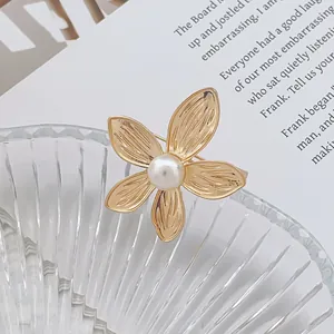 Broche fleur dorée élégante avec perle blanche sur des pétales texturés rétro