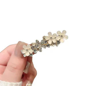 Barrette élégante en métal doré avec fleurs blanches et strass étincelants