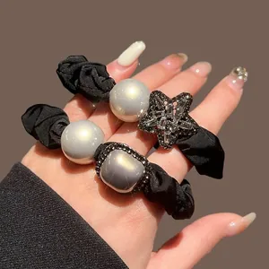 Elegant black scrunchies set with grey pearls and sparkling rhinestone star ornaments
