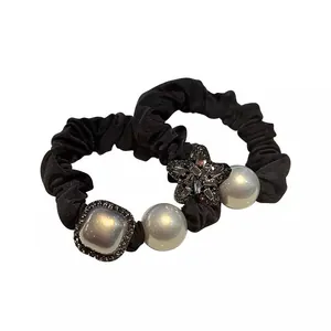 Elegant black silk scrunchies set with pearls and rhinestone star charms for high ponytail