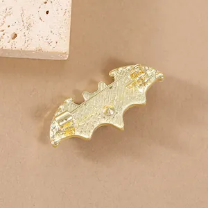 Broche chauve-souris en alliage doré avec texture travaillée et fermoir à épingle