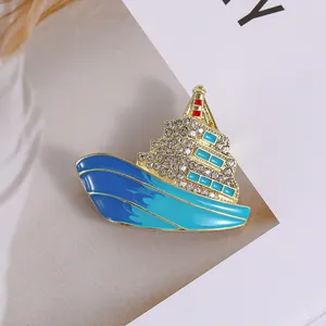 Elegante broche de crucero de lujo con esmalte azul y cristales brillantes dorados