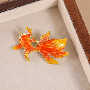 Elegant enamel koi fish brooch in orange and red gradient on a golden metal base