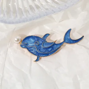 Élégante broche dauphin en émail bleu avec perle blanche sur cadre en métal doré