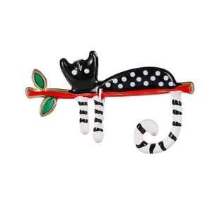 Broche chat artistique à pois noirs sur branche rouge avec feuilles vertes