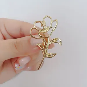 Elegante pinza para el pelo con diseño de rosa dorada hueca y detalles metalizados