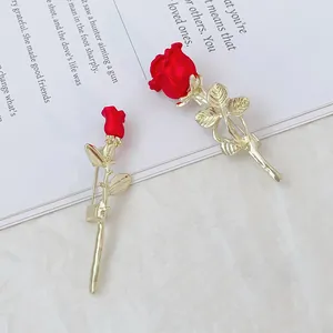 Broches élégantes rose rouge 3D avec tiges dorées et feuilles sur marbre