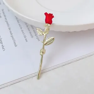 Broche fleur rose rouge 3D avec tige dorée sur fond blanc épuré et design élégant