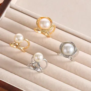 Elegante Perlenringe in Gold und Silber mit hohlem Design auf beiger Samtbox