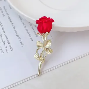 Broche rose rouge 3D dorée élégante posée sur un magazine au design minimaliste chic