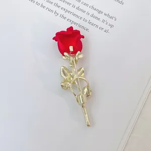 Vue détaillée de l'arrière d'une broche rose rouge avec tige dorée et accents perlés