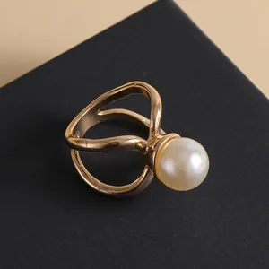 Modischer goldener Ring mit Durchbruchmuster und großer weißer Perle auf Schmuckkästchen