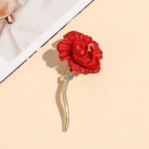 Elegant red rose brooch with gold stem and rhinestones for women on beige background