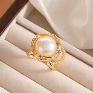 Makroaufnahme einer weißen Perle auf einem goldenen Ring in einer Schmuckschatulle