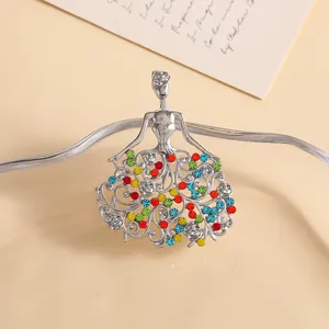 Macro shot of silver-toned angel brooch with colorful rhinestones and hollow skirt detail
