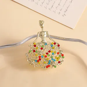 Elegant gold dancer brooch with colorful rhinestones on a stylish cream background