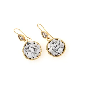 Macro shot of gold hook earrings with white stone inlay and sparkling zircon drops