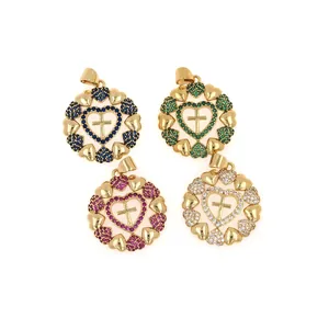 Détail de pendentifs cœur et croix plaqués or avec incrustations de zircons colorés