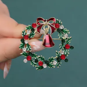 Broche couronne de Noël avec cristaux verts et nœud rouge, finition en alliage doré