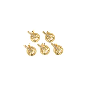 Lot de cinq pendentifs vélo en plaqué or 18 carats sertis de zircons sur fond blanc épuré