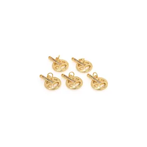 Vue macro de 5 pendentifs engrenage dorés avec zircons et design de roue creuse sur blanc