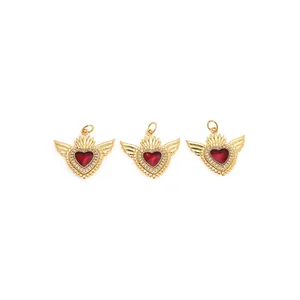Trois pendentifs cœur avec ailes plaqués or et zircon rouge sur fond blanc