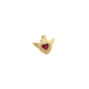 Détail macro du pendentif cœur ailé plaqué or 18K avec zircon rouge et cristaux brillants