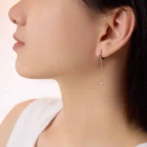 Macro detail of S925 silver fringe earrings with square zircon pendant on model