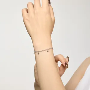 Gros plan du bracelet en argent sterling S925 avec plusieurs petits charms en cœur sur le modèle