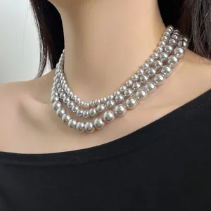 Close-up of triple-layered silver-grey pearl necklace with elegant gradient bead design