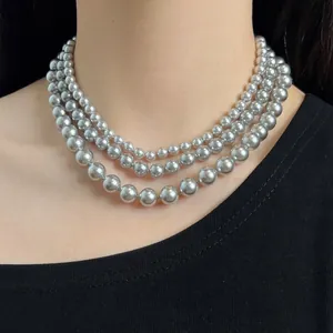 Elegant triple-layered silver pearl necklace showing smooth round beads on model