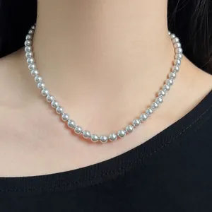 Detailed view of silver grey pearl necklace on neck showing glossy round beads