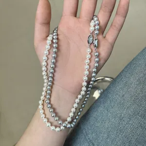Detail of white and dark grey pearl necklaces with elegant metallic clasps