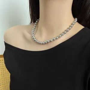 Detail of silver S925 pearl bead necklace showing metallic luster on a female model