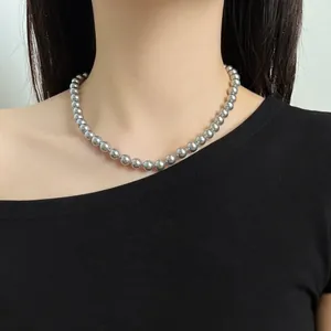 Close-up of elegant grey pearl necklace worn by a model with a black dress